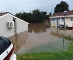 A flooded house with grass and trees

Description automatically generated