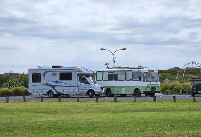A couple of rvs parked in a parking lot

Description automatically generated